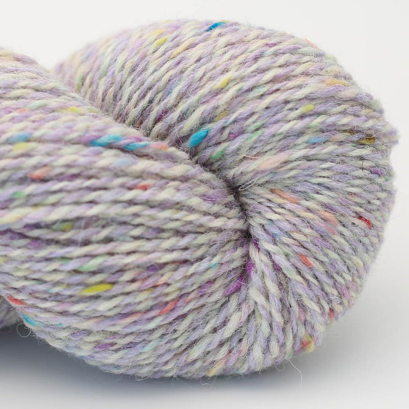 Close-up of a skein of lilac and white marled yarn with brightly coloured speckles Beara Irish wool and UK alpaca tweed dk, worsted or aran weight yarn by Hey Mama Wolf 